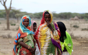 Women wait to receive food at a distribution center in Gelcha village